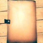 Cuaderno de cuero vintage sobre mesa de madera